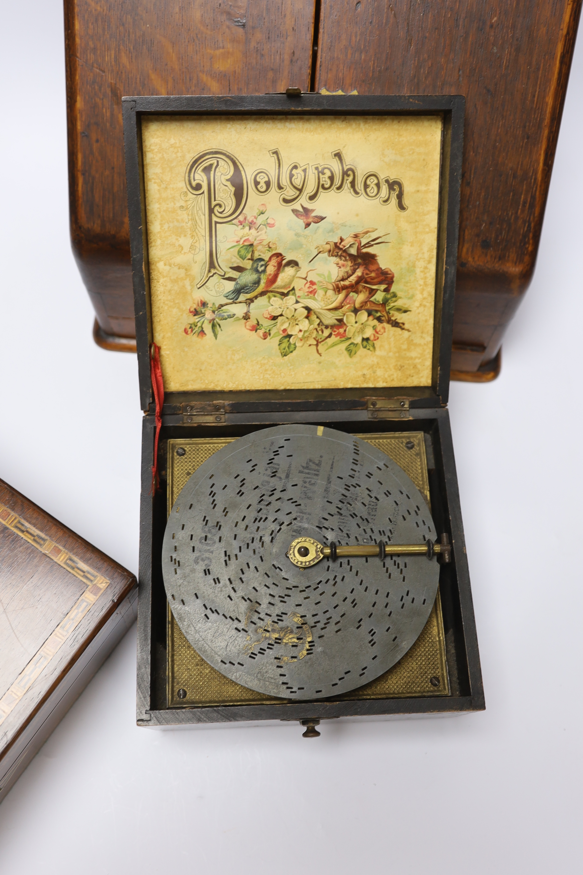 Three boxes; a miniature Polyphon, a stationery box and an inlaid jewellery box, stationery box 26cm high, 32cm wide